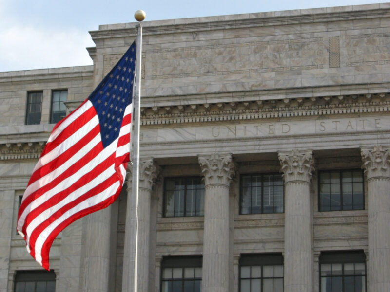 us flag waving in the wind outside a building