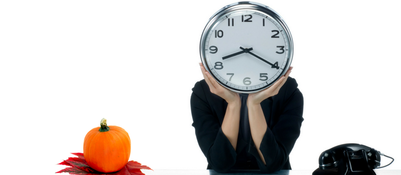 a person with a clock in front of their face with a pumpking and telephone on each side